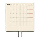 An open monthly planner with grid pages showing a calendar layouts for June, photographed on a plain white background.
