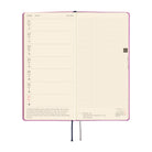 An open planner showing two interior pages: a weekly planner layout on the left and a grid page on the right. 