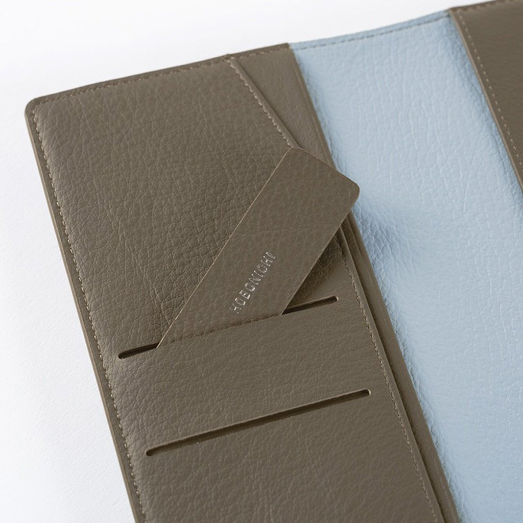 Inside of warm gray leather Hobonichi Weeks cover with light blue interior on white background