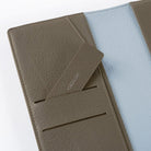 Inside of warm gray leather Hobonichi Weeks cover with light blue interior on white background