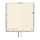 An open planner showing two interior pages: the left page has a weekly schedule layout with dates from June 21 to 27, and the right page has a light gray grid. 