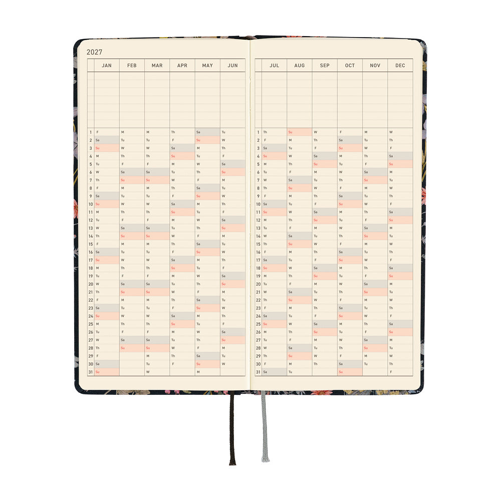 An open 2027 daily planner with cream-colored pages showing a yearly calendar grid over a two-page spread.