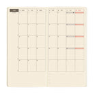 An open monthly planner spread with cream-colored grid pages showing the month of June. 