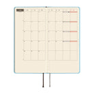 An open planner showing a two-page monthly calendar spread on cream colored paper.