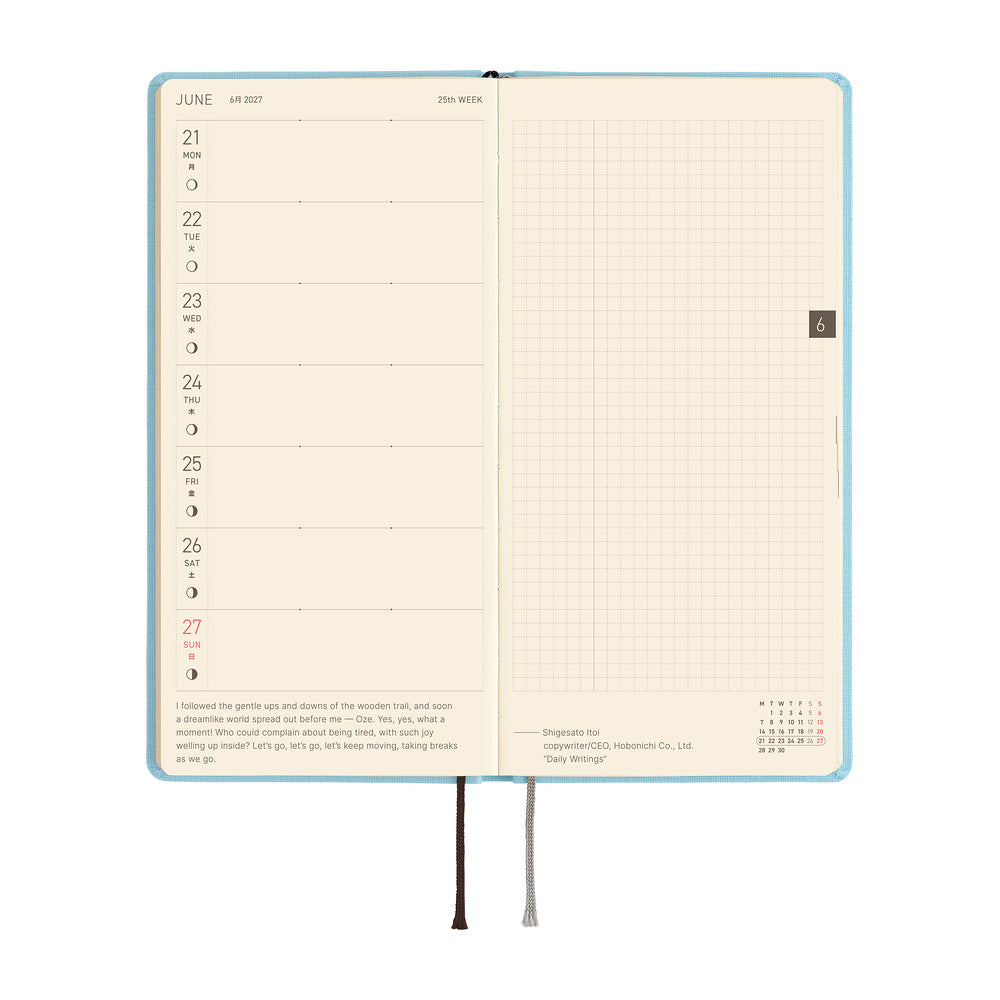 An open planner showing a weekly layout page on the left with dates and a short quote, and a grid page on the right. 
