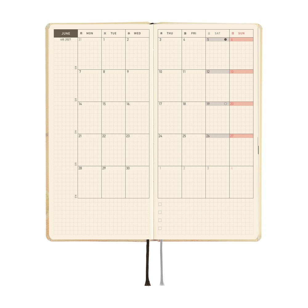 An open planner with a monthly calendar spread on cream grid paper, on a white background.