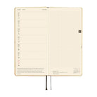 An open planner or notebook with cream-colored pages, showing a weekly layout on the left side and a grid section on the right. 