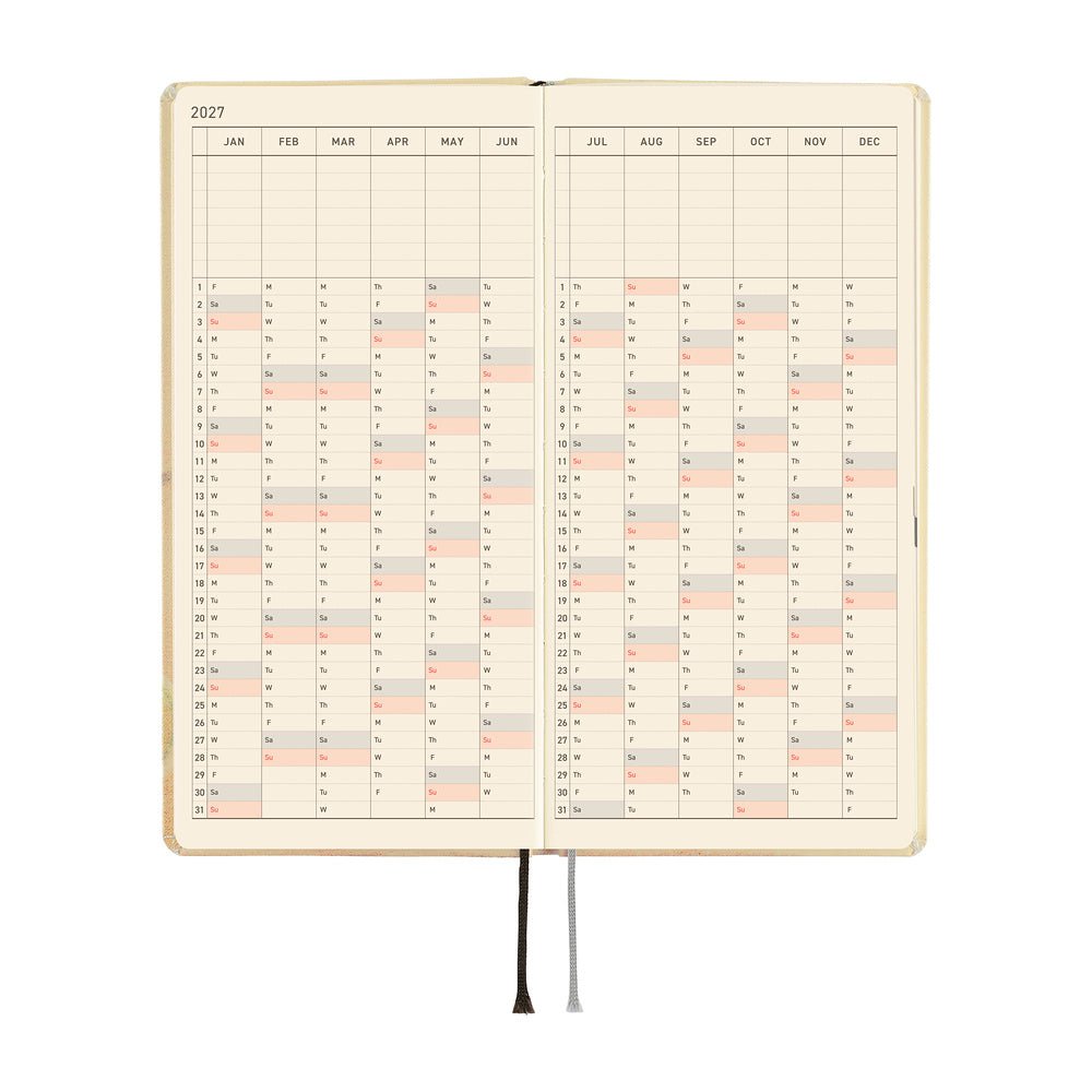An open 2027 daily planner with cream-colored pages featuring a detailed yearly calendar grid.
