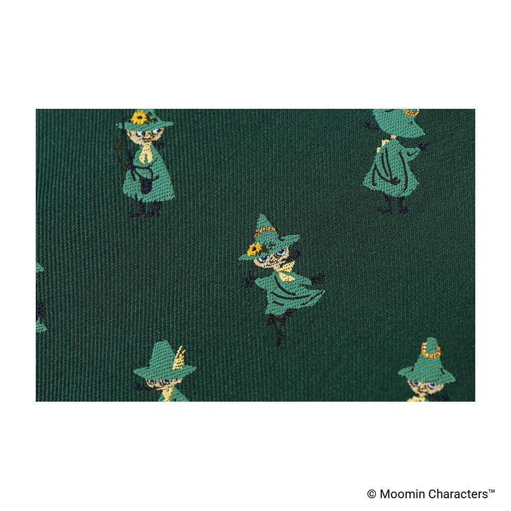 A close-up photo showing one of the Moomin characters woven into dark green fabric.