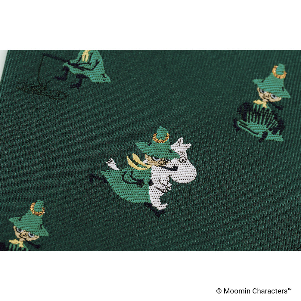 A close-up photo showing one of the Moomin characters woven into dark green fabric.