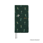 A dark green planner covered with woven "bow & tie" fabric featuring Moomin characters and the year '2027' in gold foil.
