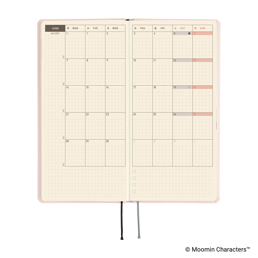 An open planner with a monthly calendar spread on cream grid pages, shown on a white background. 