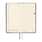 An open planner showing a two-page spread: the left page has a weekly schedule layout for June 21-27 with small time slots and a short quote, and the right page has a  grid for writing. 