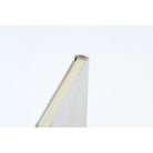 A close-up shot of the binding of a planner book with a silver leather cover and cream colored pages. 