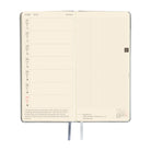 An open daily planner showing a two-page spread with a cream-colored left page featuring a weekly layout and a right page with a grid layout.