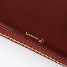 Red leather zippered notebook case with gold 'handwrite' branding