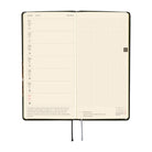 An open planner showing a weekly spread with a left column for Monday through Sunday and a blank grid page on the right.