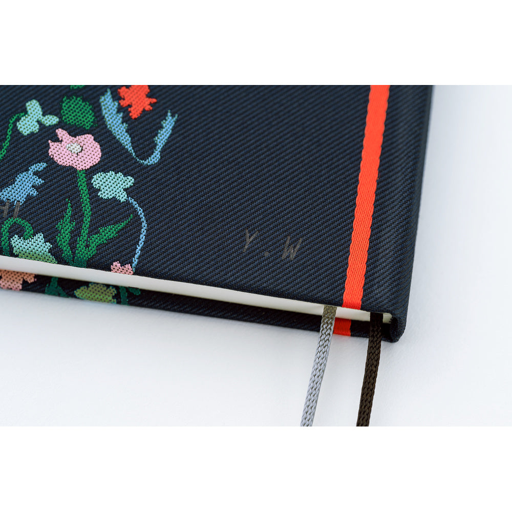 A close-up shot of the back cover of a navy blue planner, featuring the designer's initials, "Y.W."
