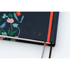 A close-up shot of the back cover of a navy blue planner, featuring the designer's initials, "Y.W."