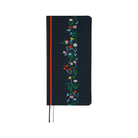A dark navy blue planner with a vertical floral vine design in green, pink, blue, yellow, and white along the right side. It features a bright red band near the spine and ribbon bookmarks hanging from the bottom.