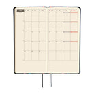 An open monthly planner on cream colored pages, shown on a plain white background.