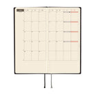 An open monthly planner with two grid pages showing a calendar layout for June, with black and gray ribbon bookmarks hanging below on a plain white background.