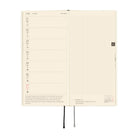 An open weekly planner spread on a white background, showing a left column for Monday through Sunday with dates and brief prompts, and a right column with light gray grid squares. The pages are cream-colored with black text and small red accents.