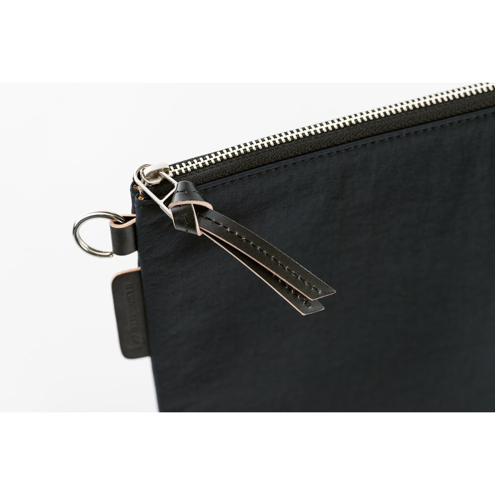 Black zippered pouch with a keychain on a white background