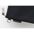 Close-up of a black zip pouch with a silver metal ring and zipper pull, featuring a small black brand tab that reads HANDWRITE on a white background.