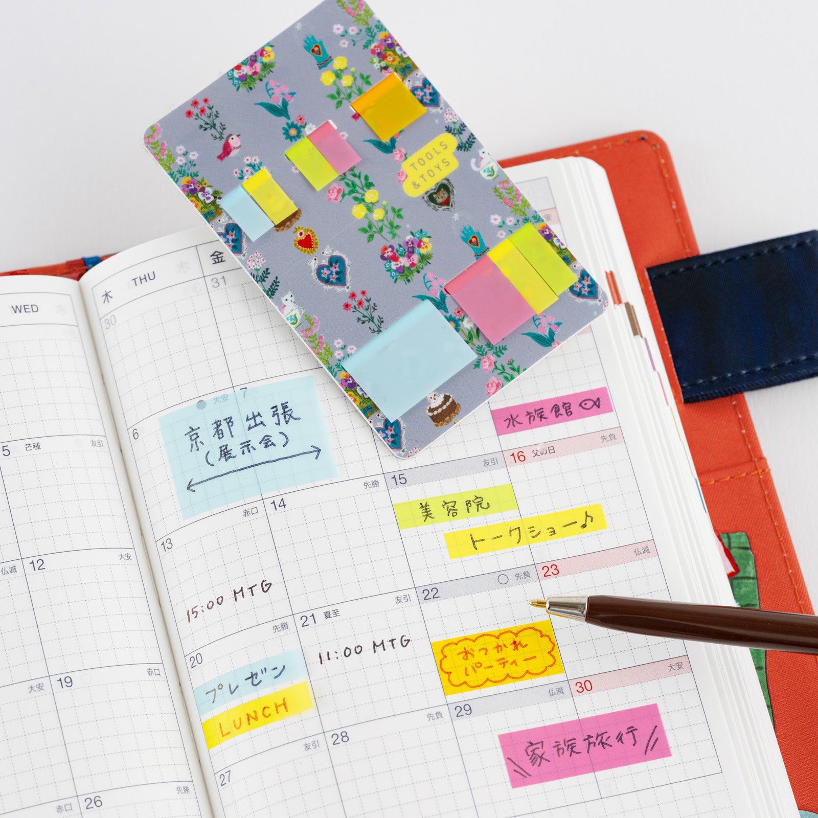 Colorful Hobonichi translucent sticky notes on calendar page