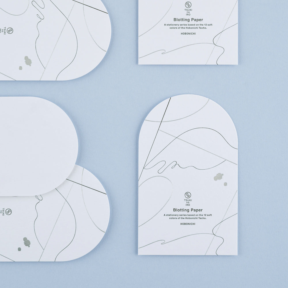 A set of arched sheets of blotting papers shown on a clean blue background. The paper features minimalist black abstract line art and text detailing its features.