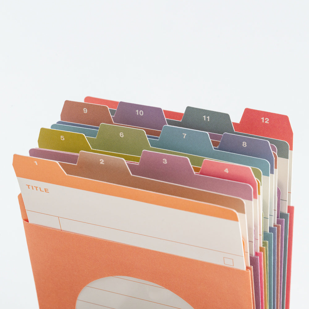 A set of colorful paper file folders arranged in a fan shape on a white background. The tabs are numbered 1 through 12 and come in multiple pastel and bright colors including orange, pink, purple, blue, green, and red.