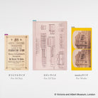 Three Hobonichi Techo pencil boards with designs from the V&A Museum. The center item is an A5 pale pink board with architectural line drawings; the left item is an A6 tan pencil board with black text; the right item is a Weeks-sized yellow board with two stacked printed images.
