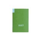 Green Hobonichi weekly calendar with blue '2027' text on front on white background