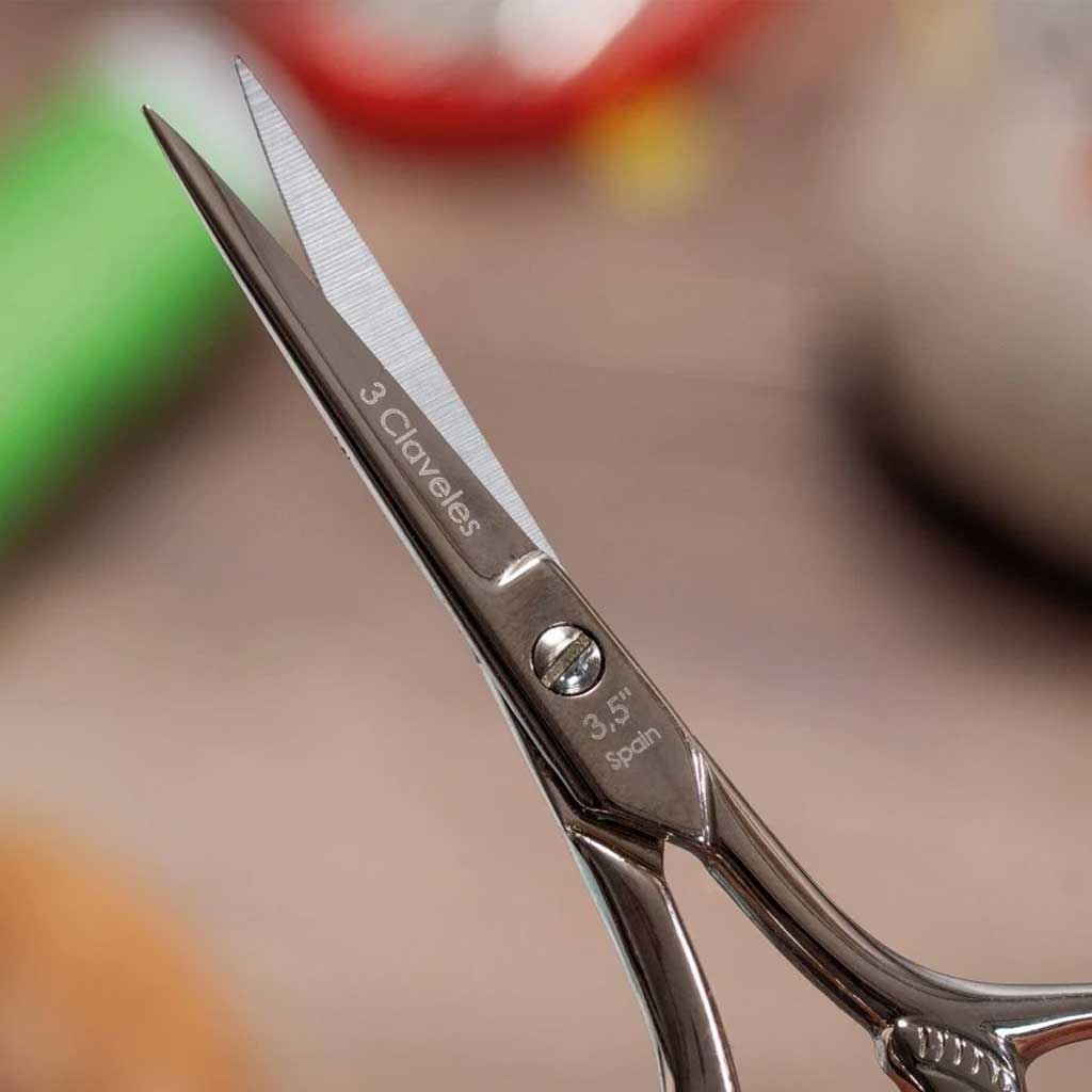 Close-up of a pair of scissors with brand name on a blurred background