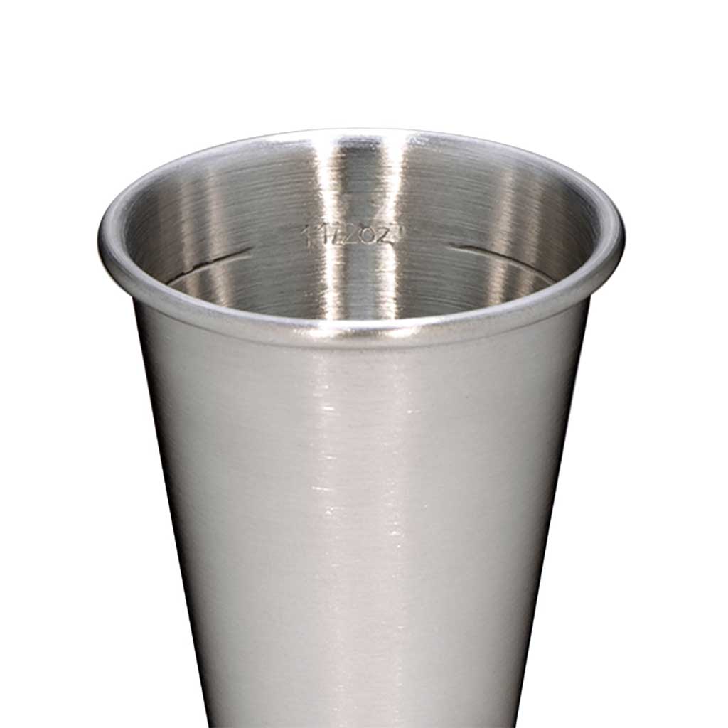 Close up of stainless steel cocktail jigger with interior 1 1/2 oz marking on white background