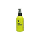 Yellow bottle of face cleanser with black pump cap on a white background