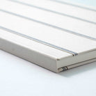 Close-up of a striped bound book with white pages on a white background