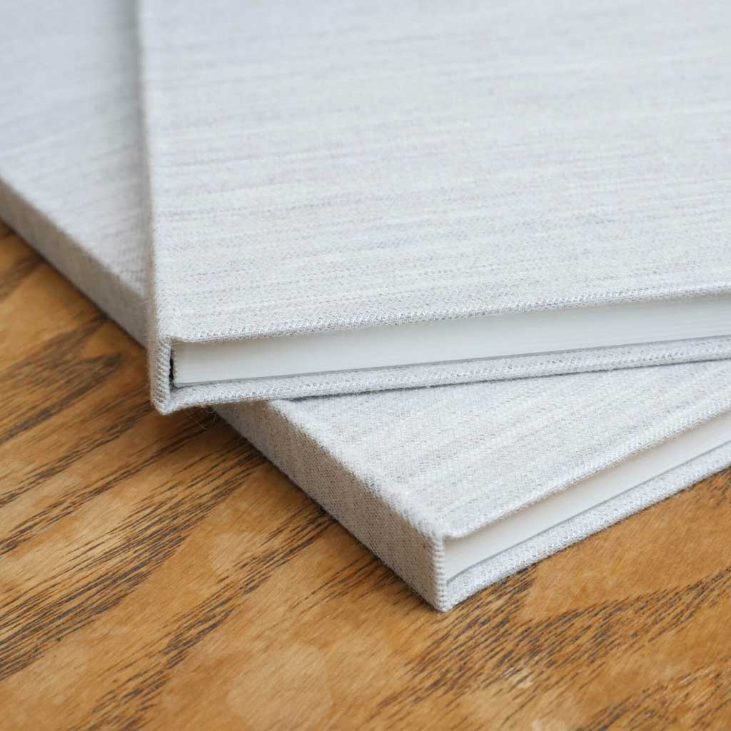 Two gray notebooks on wooden surface