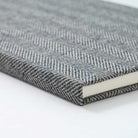 Close-up of a textured gray notebook on a white background