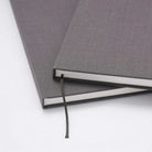 Gray textured notebook with a bookmark on a white background
