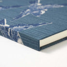 Notebook with a blue cover featuring white bird pattern on a white background