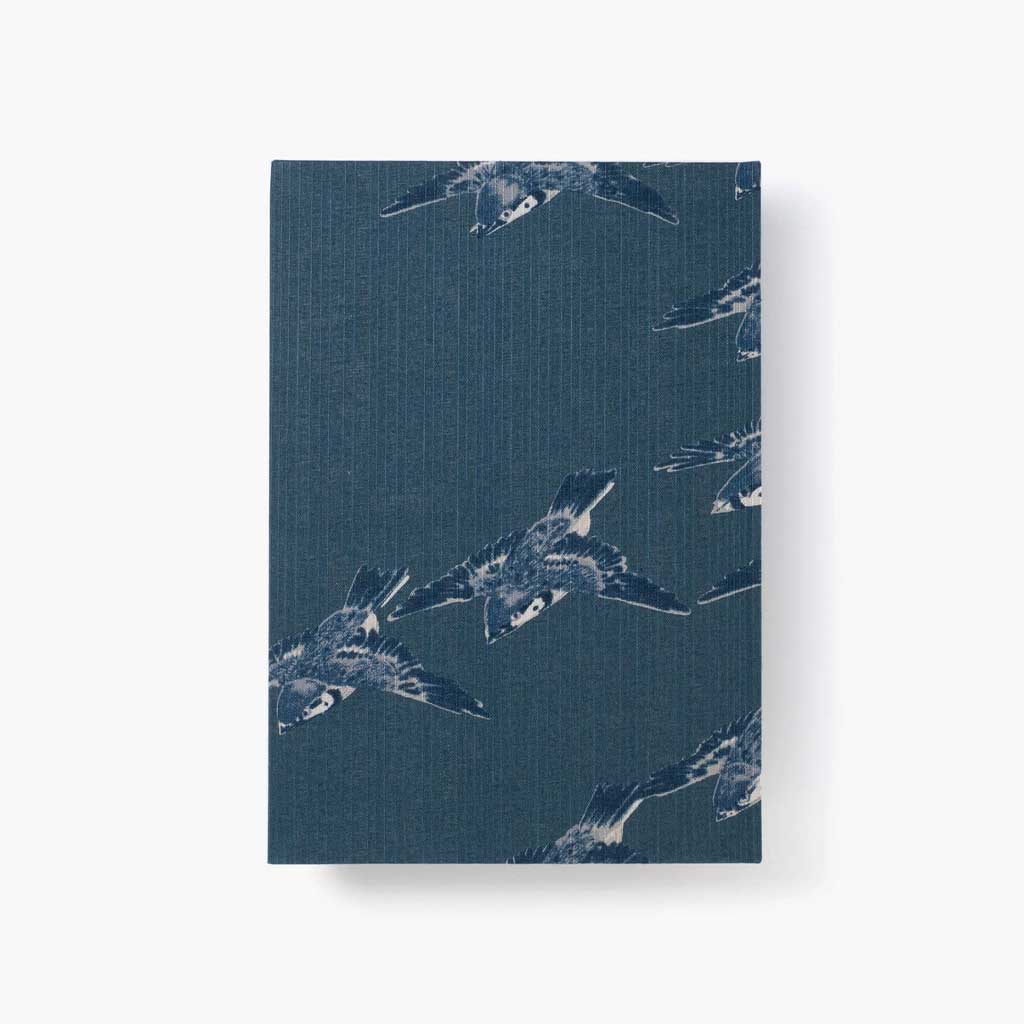 Notebook with a blue cover featuring white bird pattern on a white background