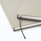 Close-up of two notebooks with woven covers and stranded bookmarks.