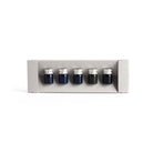 Set of five small ink bottles with silver caps in a gray box on a white background