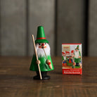 Wooden incense smoker figurine in a green coat and hat, holding a staff and pipe, beside a colorful Knox incense box.