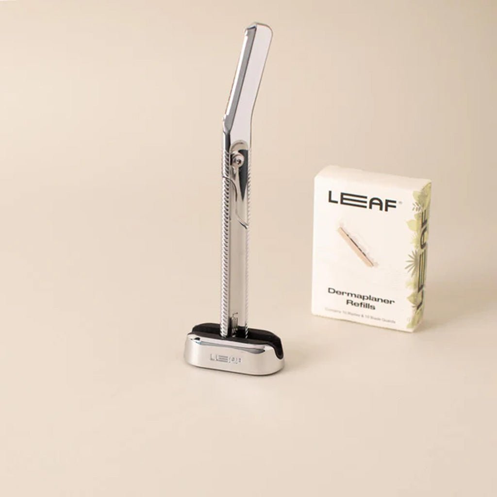 Dermaplaning tool with LEAF branding on a beige background