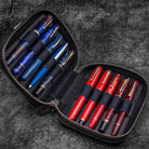 Black leather zippered pen pouch with ten colorful pens on a dark surface