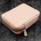 Natural undyed leather zippered pen pouch on a dark surface