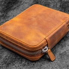 Crazy horse brown leather zippered pen pouch on a dark surface
